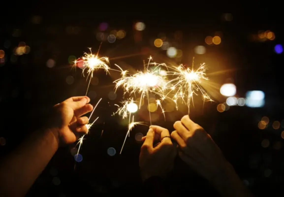 Prskavky v rukách hostí počas silvestrovskej oslavy